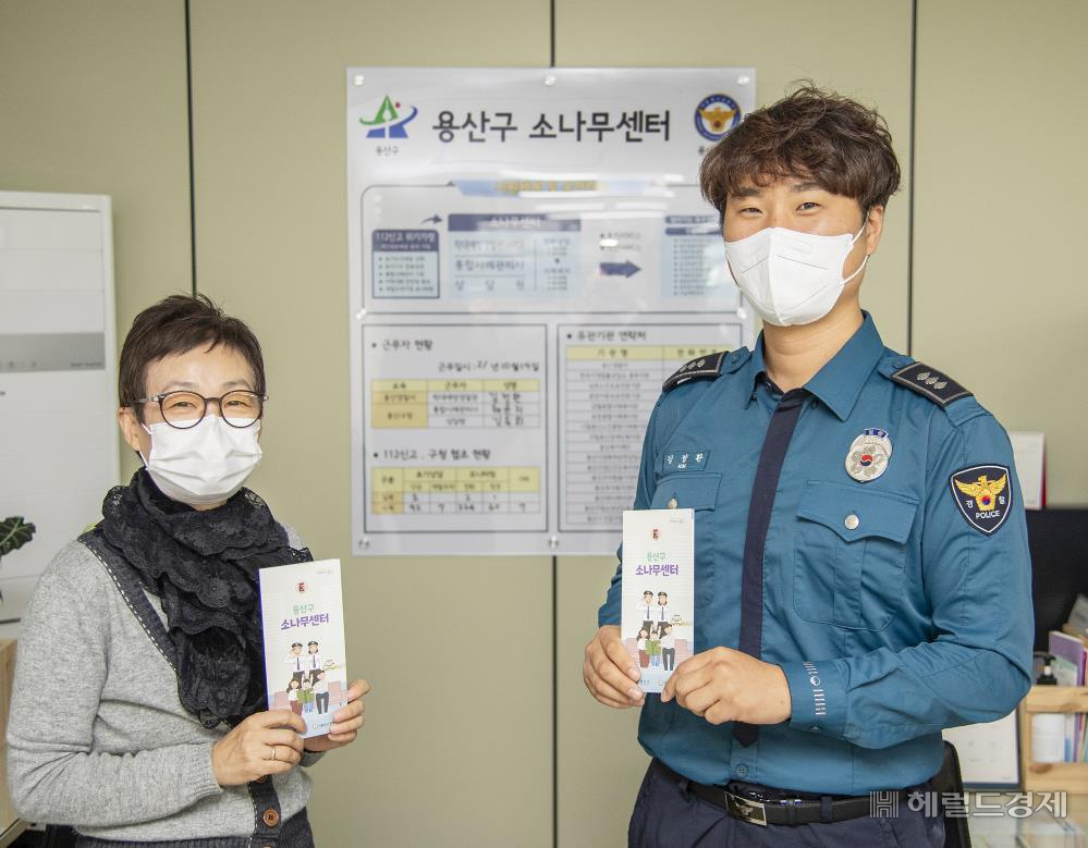 용산구 소나무센터 직원과 경찰이 센터 홍보물을 들어보이고 있다. [용산구 제공]