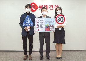 롯데건설 하석주(가운데) 대표이사와 임직원들이 20일 서초구 잠원동에 위치한 본사에서 ‘어린이 교통안전 릴레이 캠페인’에 동참하고 있다. [롯데건설 제공]
