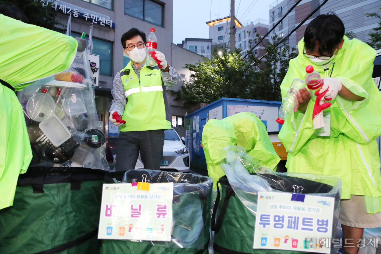 정원오(왼쪽) 성동구청장이 지난 6월 왕십리2동 푸르미 재활용정거장에서 자원관리사들과 재활용품을 가려내고 있다. [성동구 제공]