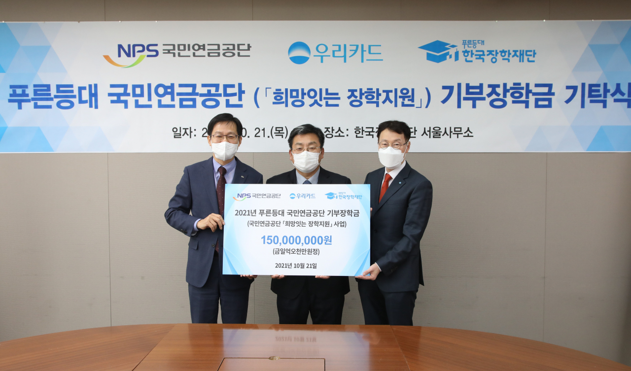 21일 한국장학재단 서울사무소 대회의실에서 국민연금공단 김정학 연금이사(왼쪽)가 한국장학재단 서병재 상임이사(가운데), 우리카드 이인복 상무(오른쪽)와 함께 기념촬영을 하고 있다.