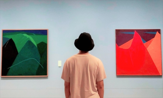 대구미술관의 ‘이건희 컬렉션’ 전시에 걸린 유영국 작품을 배경으로 한 방탄소년단 RM의 사진이 올라오자 이곳은 아미와 관람객의 포토존이 됐다. [방탄소년단 트위터 캡처]