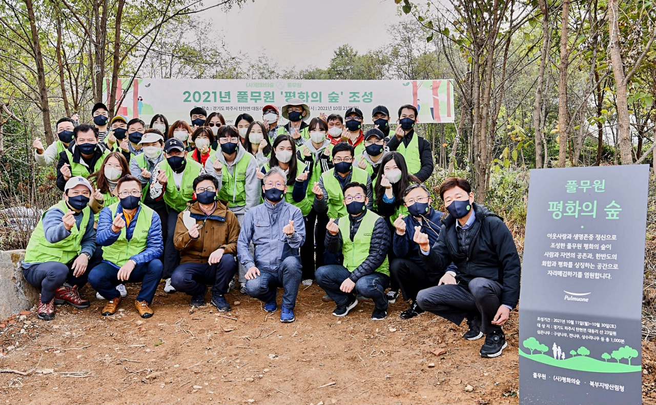 21일 경기도 파주 접경지역에서 진행된 '풀무원 평화의 숲' 조성 행사에서 이상부(앞줄 오른쪽 세번째) 풀무원 전략경영원장, 김재현(앞줄 오른쪽 네번째) 평화의숲 대표, 최수천(앞줄 오른쪽 다섯번째) 북부지방산림청장, 강기래(앞줄 오른쪽 첫번째) 서울국유림관리소장등 주요 관계자들 및 풀무원 임직원들과 기념촬영을 하고 있다. [풀무원 제공]