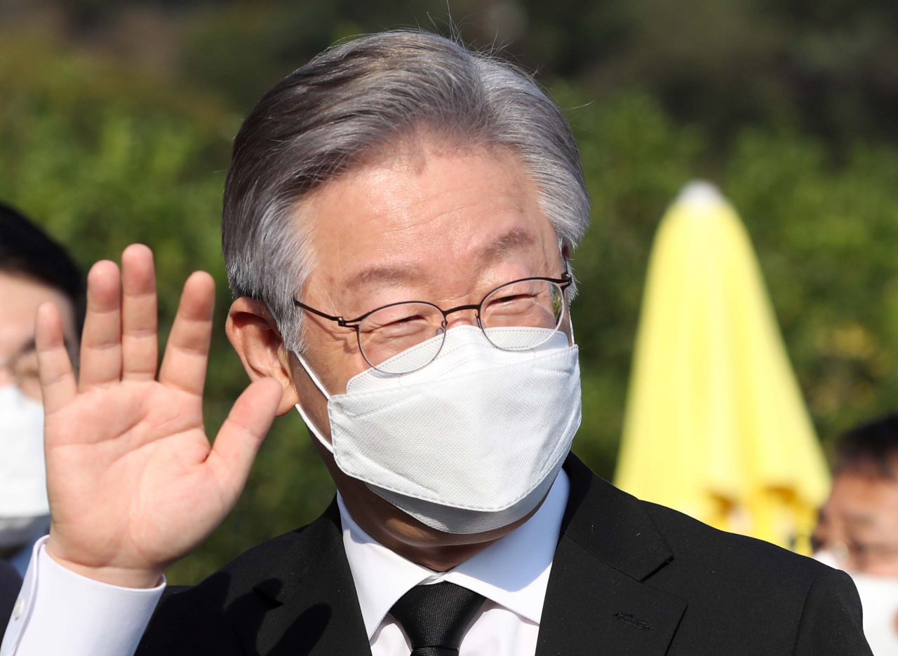 더불어민주당 대선 후보인 이재명 경기도지사가 22일 오후 경남 김해시 진영읍 봉하마을 노무현 전 대통령 묘역 참배 후 권양숙 여사 예방에 앞서 지지자에게 손 인사하고 있다. 연합뉴스