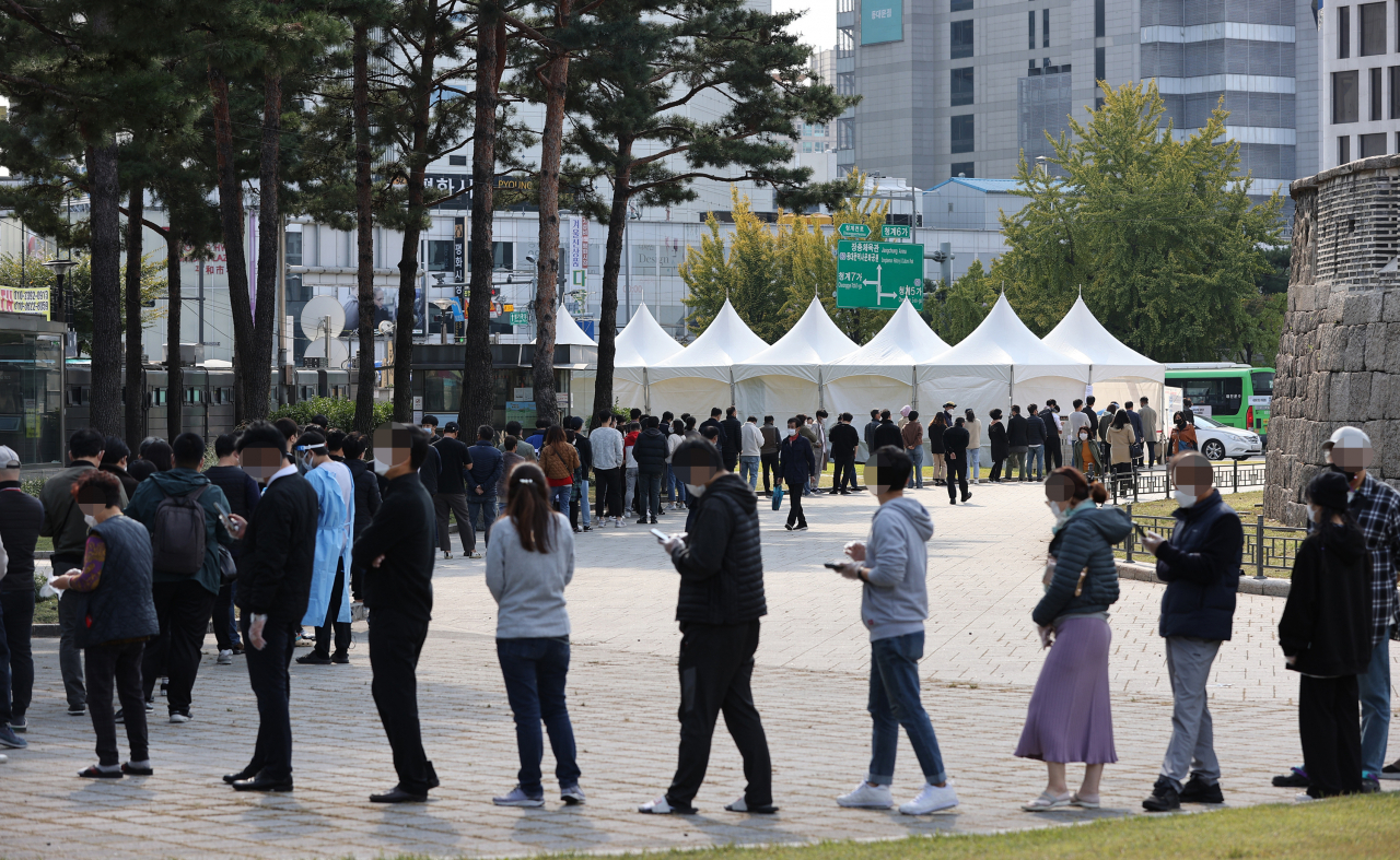 22일 오후 서울 종로구 흥인지문 앞에 설치된 찾아가는 임시선별진료소에서 인근 시장 상인과 시민 등이 코로나19 선별검사를 받기 위해 순서를 기다리고 있다. [연합]