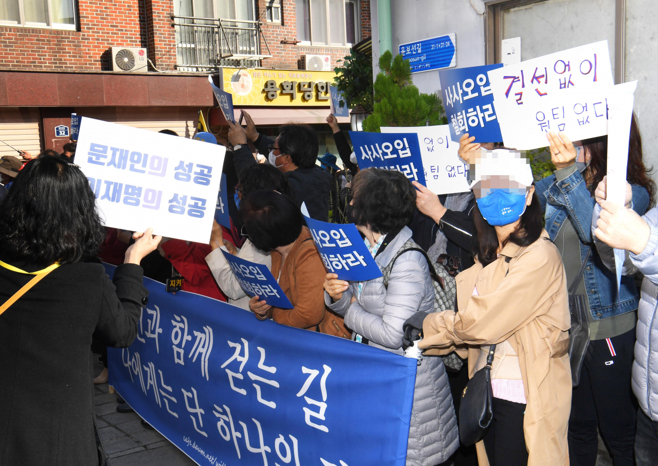 24일 오후 더불어민주당 대선 후보인 이재명 경기도지사와 이낙연 전 대표의 회동 장소인 서울 종로구 안국동 한 찻집 인근에 양측 지지자들이 손팻말을 들고 있다. [연합]