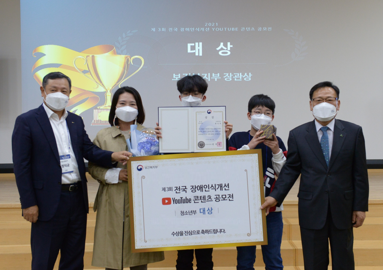 정덕균 포스코ICT 사장(좌측 첫번째)과 김광환 한국지체장애인협회 중앙회장(좌측 다섯번째)이 장애인식개선 유튜브 공모전 청소년부 대상 수상자 황정현 군(좌측 세번째)과 기념촬영을 하고있다. [포스코ICT 제공]