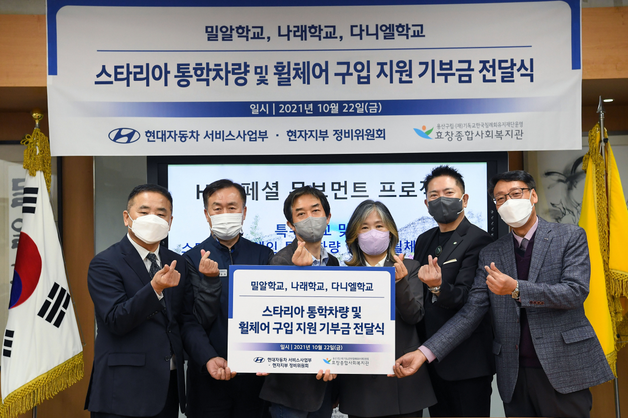 지난 22일 강남구 일원동 소재 밀알학교에서 이정민 효창복지관장(왼쪽부터), 남강희 현자지부 정비위원회 의장, 현대차 서비스사업부장 최희복 상무, 김정선 나래학교장, 최병우 밀알학교장, 이성만 다니엘학교감 등이 참석한 가운데 ‘스타리아 통학차량 및 휠체어 구입 지원 기부금 전달식’을 갖고 기념사진을 찍고 있다. [현대차 제공]