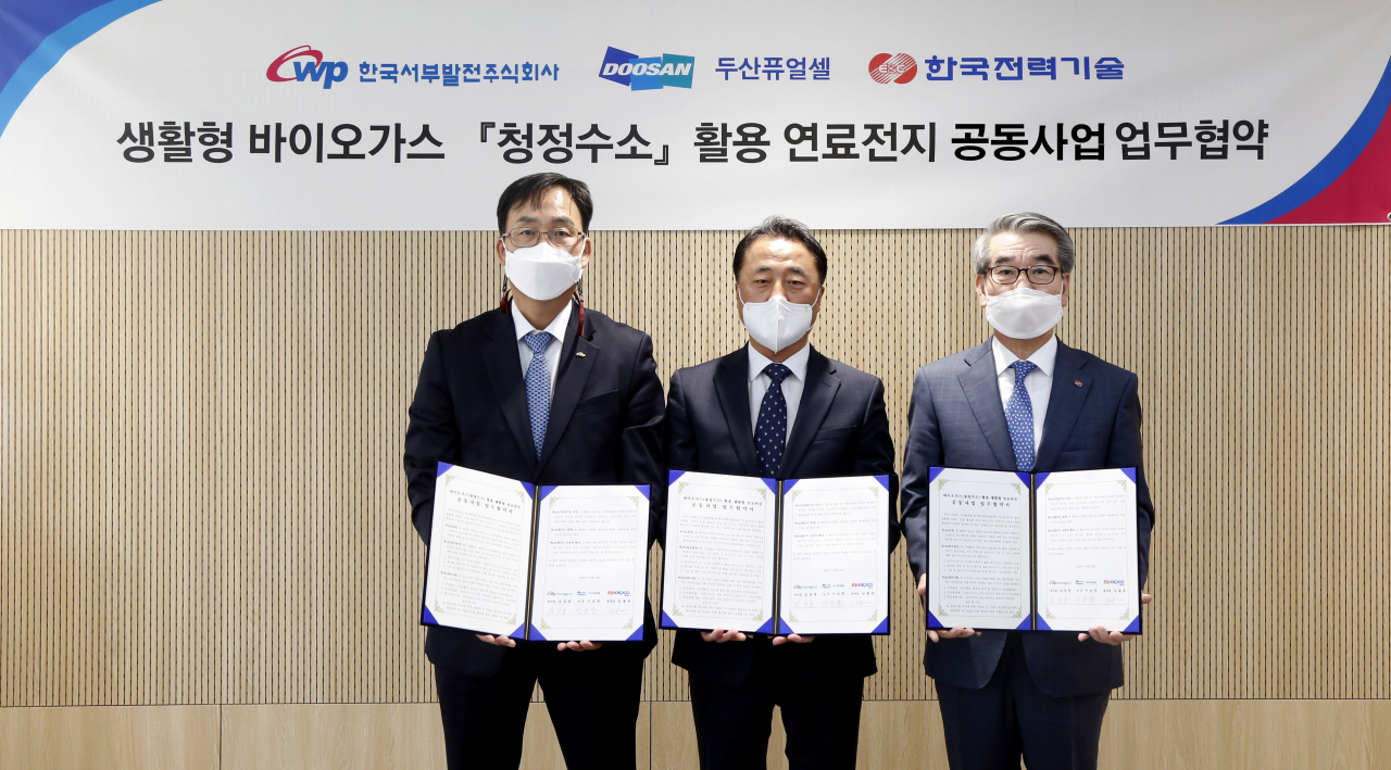 김성균(왼쪽) 한국서부발전 성장사업본부 부사장이 25일 한국전력기술, 두산퓨어셀과 '생활형 바이오가스 청정수소 활용 연료전지 공동사업 업무협약'을 체결한 후 기념촬영을 하고 있다.［한국서부발전 제공］