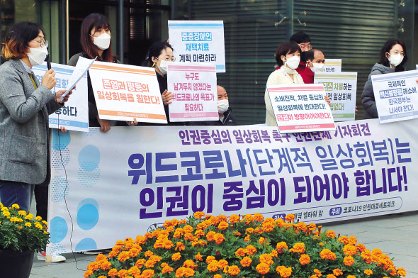 백신 접종률이 지난 23일 70%를 넘어서면서 정부가 11월 1일부터 위드 코로나 전환 시행을 검토하고 있다. 정부는 오는 29일 일상회복 이행계획을 발표할 계획이다. 인권운동네트워크 등 인권단체 활동가들이 22일 오전 단계적 일상회복 관련 2차 공개토론회가 열리는 서울 서초구 엘타워 앞에서 기자회견을 열고 집회 시위 권리 보장과 백신 패스 중단 등 인권 중심의 일상 회복을 촉구하고 있다. [연합]