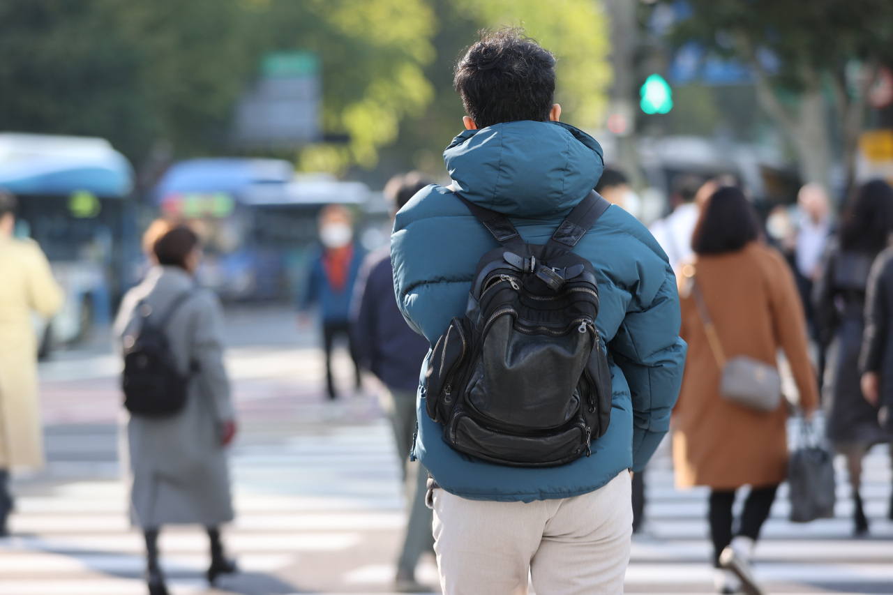 Pedestrians cross a street near Gwanghwamun Square in Seoul on Oct. 20. (Yonhap)