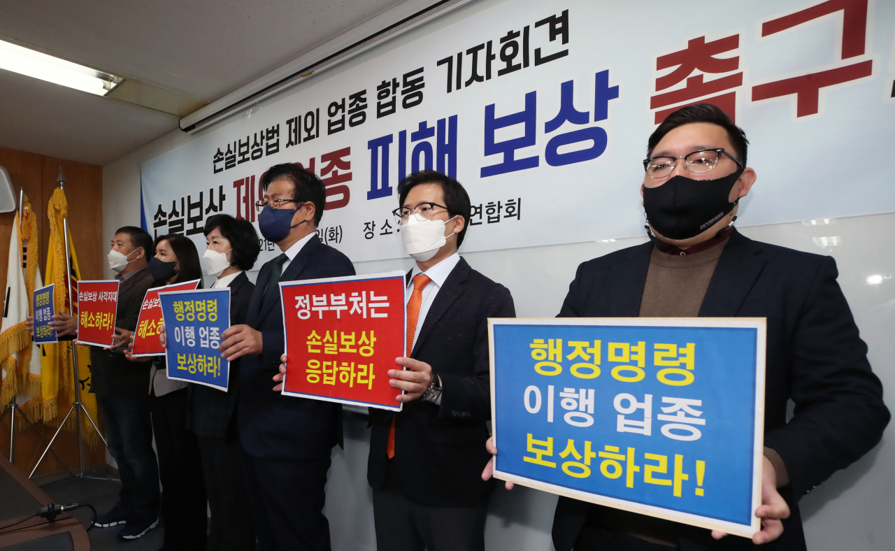 26일 서울 영등포구 여의도동 소상공인연합회에서 열린 손실보상법 제외 업종 피해보상 촉구 합동 기자회견에서 참석자들이 손팻말을 들고 구호를 외치고 있다. [연합]