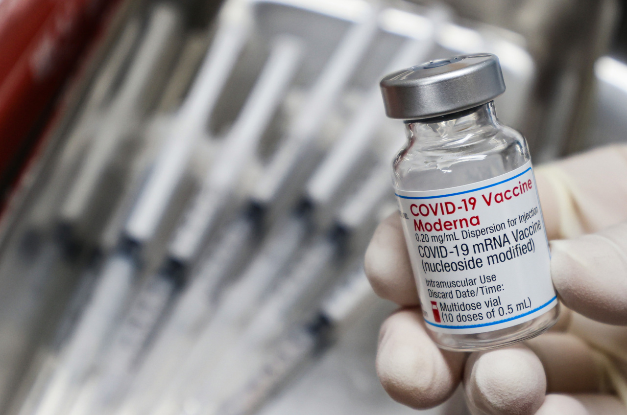 This photo shows a health care worker holding a vial of Moderna COVID-19 vaccine. (Yonhap)