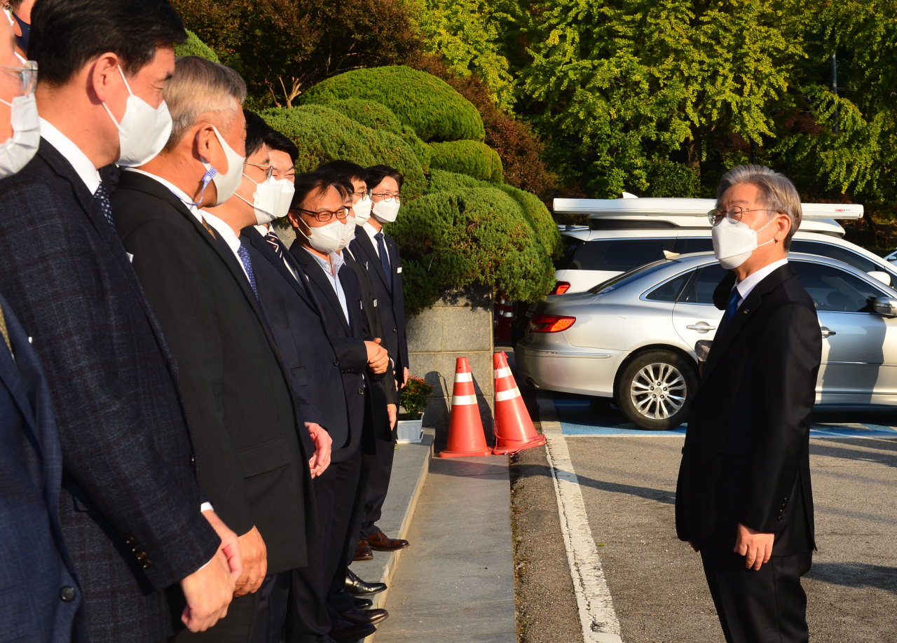 Lee Jae-myung, presidential nominee for the ruling Democratic Party, exchanges remarks with officials of Gyeonggi provincial government after announcing his resignation from the gubernatorial post Monday. (Joint Press Corps)