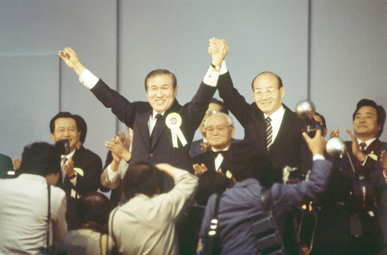 사진은 1987년 민정당 전당대회에서 대통령 후보로 지명된 노태우 대표가 전두환 대통령과 손을 맞잡고 대의원들의 환호에 답하는 모습. [연합]