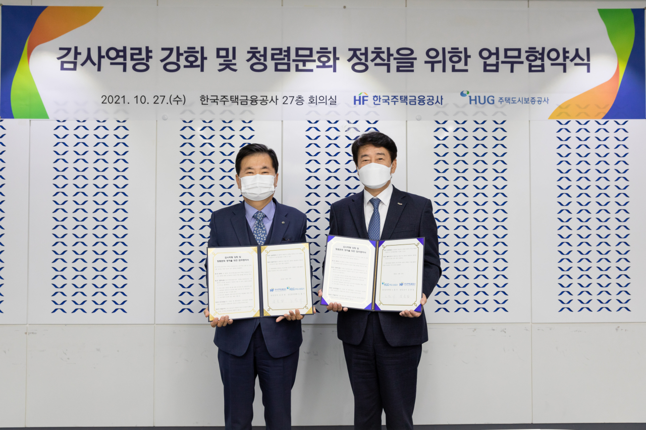 27일 부산국제금융센터에서 노융기(오른쪽) HUG 상근감사위원과 김준일 한국주택금융공사 상임감사가 감사 업무협약 체결 후 기념 촬영을 하고 있다. [HUG 제공]