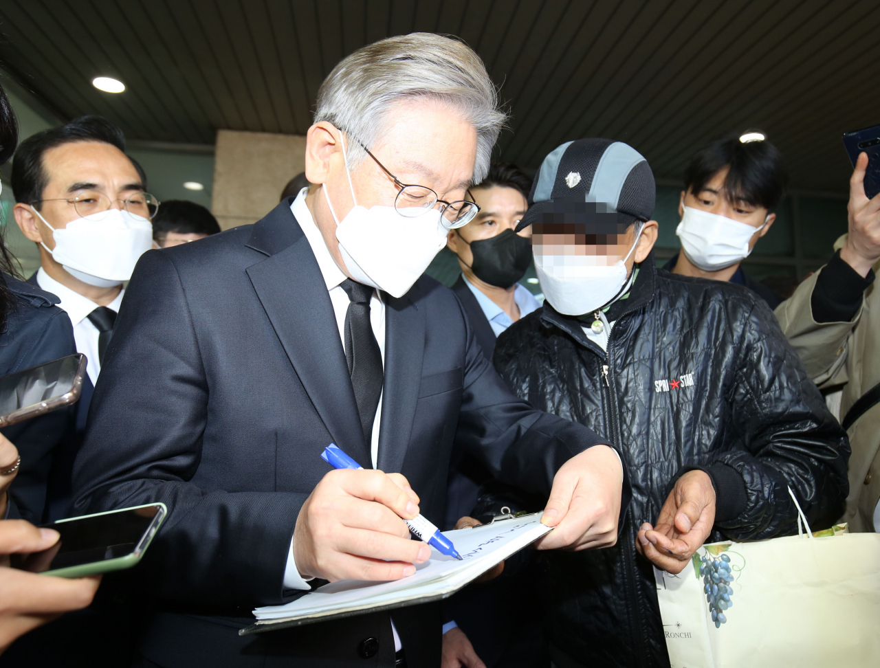 더불어민주당 이재명 대선 후보가 27일 서울대병원 장례식장에 마련된 노태우 전 대통령 빈소를 찾아 조문한 뒤한 시민의 요청으로 사인해 주고 있다. 연합뉴스