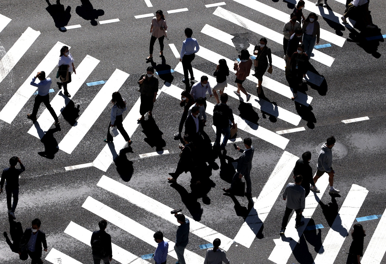 Workers cross the road in Jongno-gu, central Seoul, as they head for lunch earlier this month. (Yonhap)
