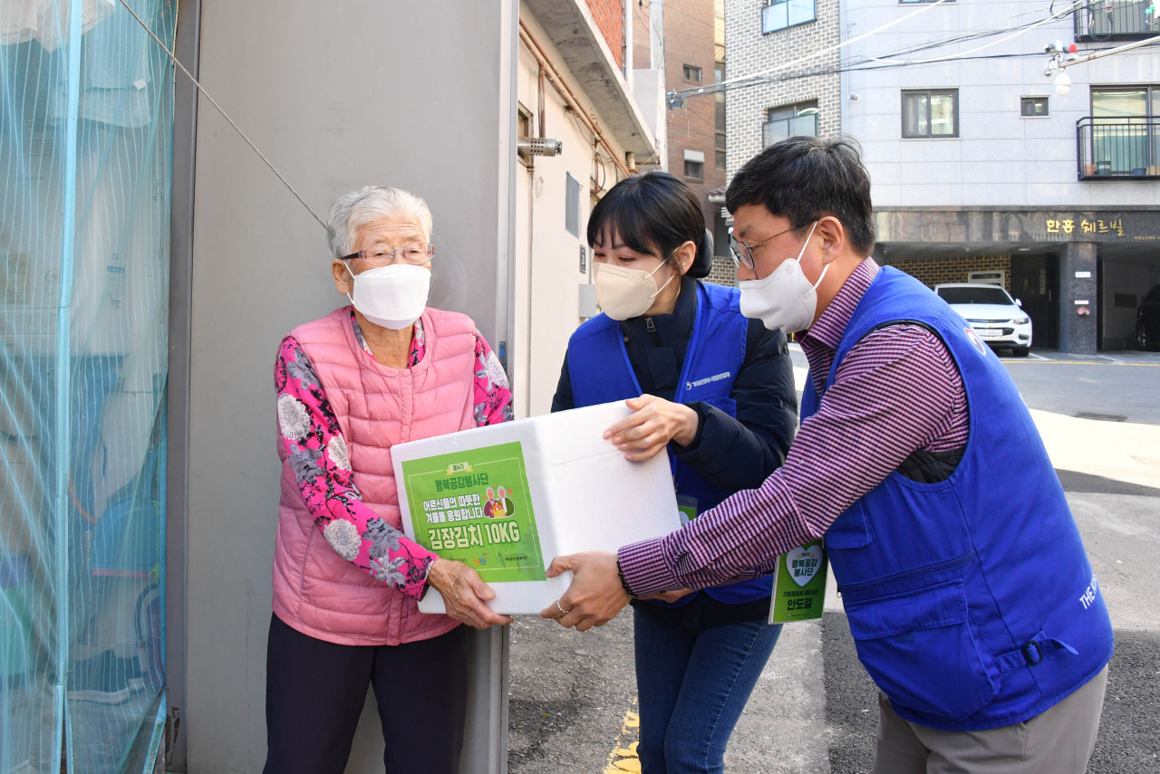 안도걸 기획재정부 차관이 지난 27일 서울 목동종합사회복지관 일대에서 진행된 '행복공감봉사단 제3차 봉사활동'에 참석, 홍보대사인 김소연 씨와 어르신들에게 김치를 전달하고 있다. [기획재정부 제공. 재판매 및 DB 금지] 연합뉴스