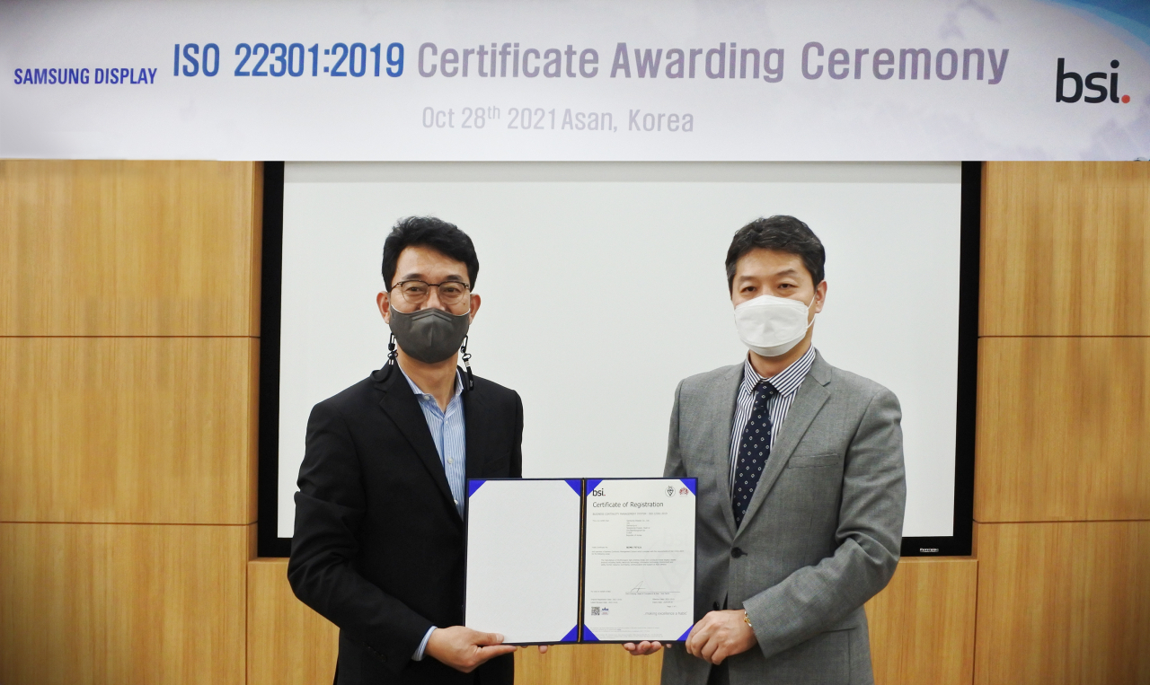 삼성디스플레이 아산캠퍼스에서 28일 삼성디스플레이 글로벌인프라 총괄 최송천 전무(왼쪽)가 임성환 BSI Korea 본부장에게 ISO 22301 인증서를 전달 받고 있다. [삼성디스플레이 제공]