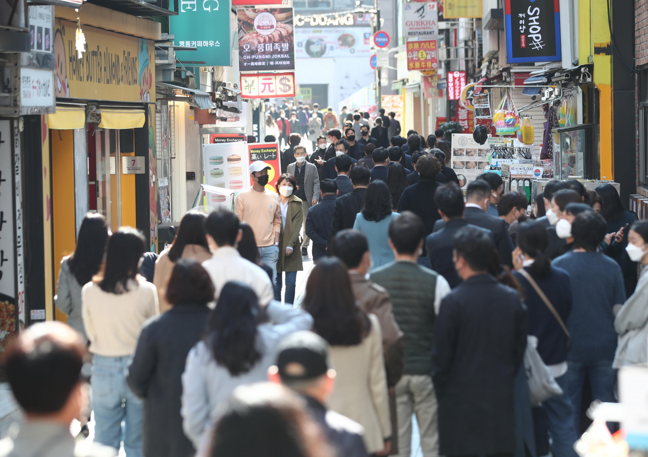 다음달부터 본격 시행되는 '단계적 일상회복(위드코로나)' 방역체계 전환을 앞둔 25일 오후 서울 명동 거리에서 점심식사를 하려는 시민들로 붐비고 있다. 연합뉴스