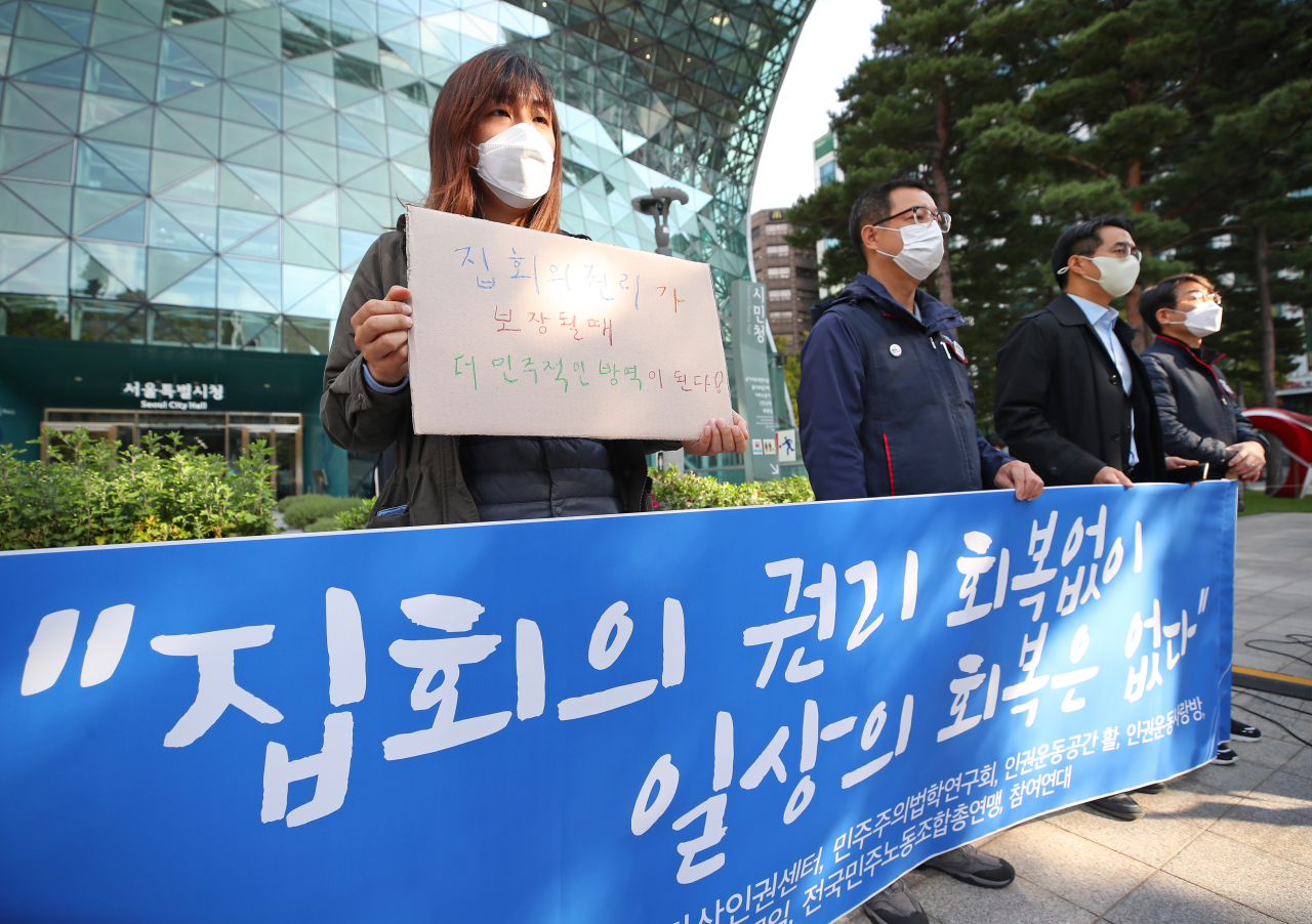 공권력감시대응팀, 민주사회를위한변호사모임,참여연대 및 민주노총 관계자 등이 정부의 '단계적 일상회복' 조치 발표가 예정된 29일 오전 서울시청 앞에서 기자회견을 열고 집회의 권리 회복을 촉구하고 있다. [연합]