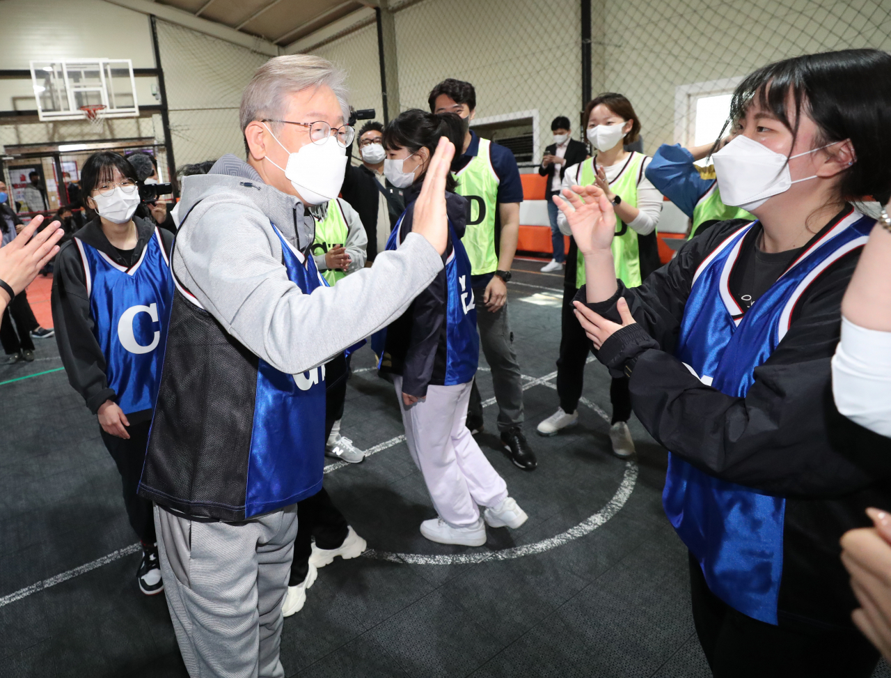 이재명 더불어민주당 대선 후보가 31일 오전 경기도 고양시 덕양구 상암 농구장에서 2030 여성들과 '넷볼'(영국에서 농구를 모방해 만들어진 여성 전용 스포츠) 경기를 마친 뒤 참석자들과 하이파이브 하고 있다. [연합]