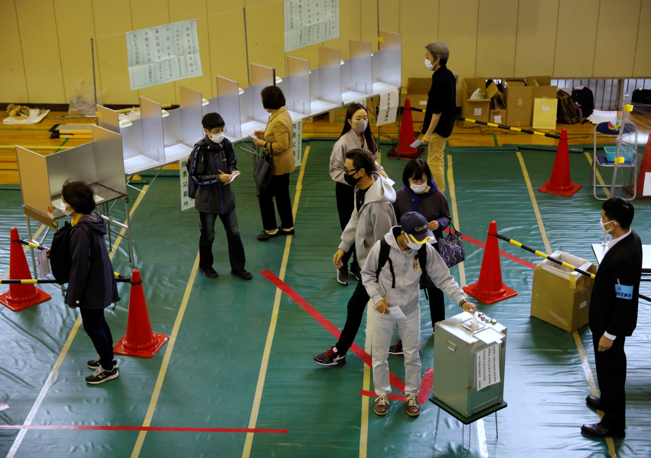 일본 수도 도쿄의 한 투표소에서 31일 신종 코로나바이러스 감염증(코로나19) 예방 마스크를 쓴 유권자들이 중의원(하원) 선거 투표를 하고 있다. 이달 초 출범한 기시다 후미오(岸田文雄) 내각을 심판하는 이번 총선은 집권 자민당의 단독 과반 의석 확보 여부가 관전 포인트다. [연합]