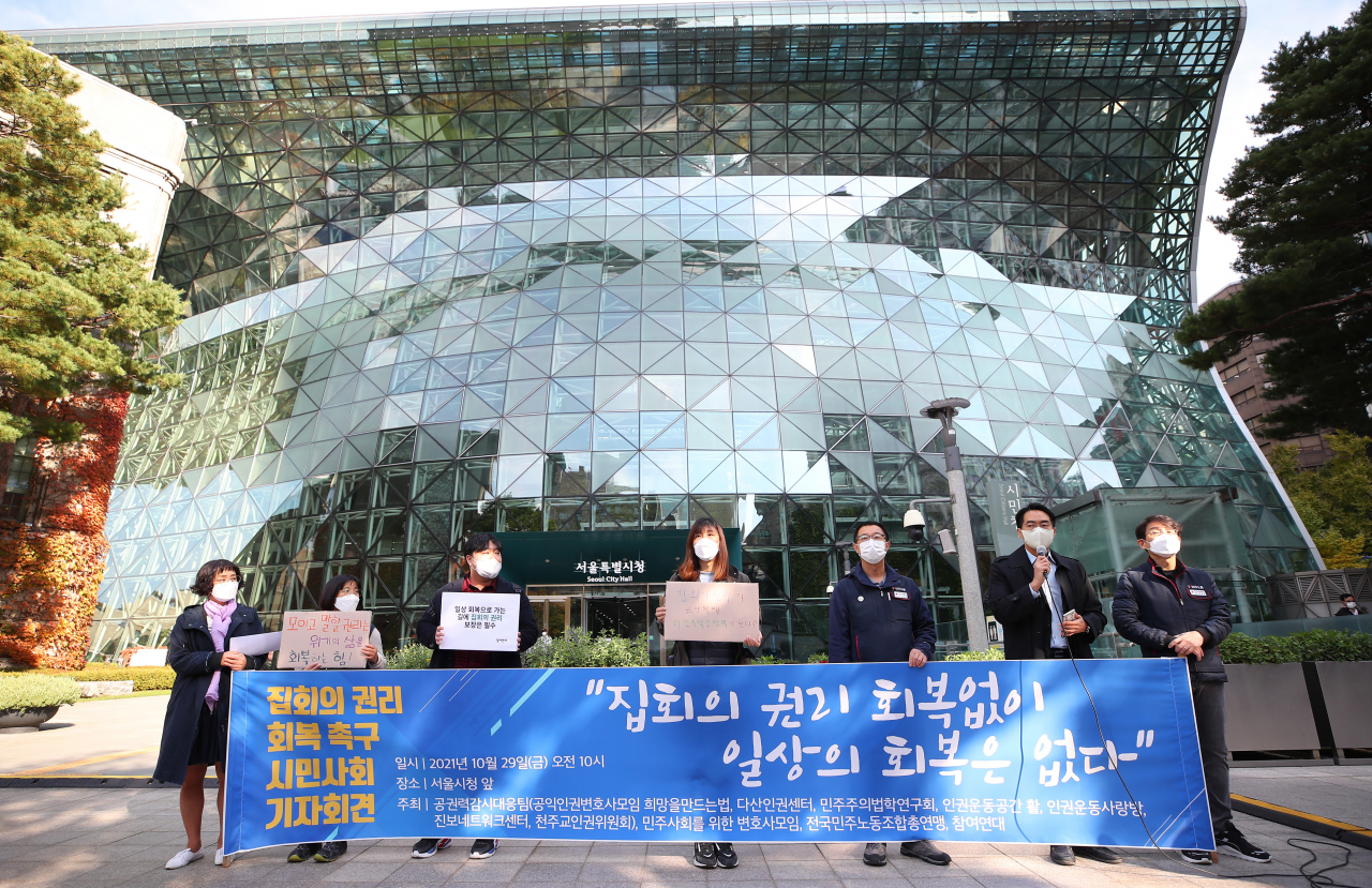 11월 1일부터 적용되는 1단계에서 신종 코로나바이러스 감염증(코로나19) 백신 미접종자에 한해 집회에 최대 100인 미만까지 열 수 있고 접종 완료자나 음성확인자의 경우 500인 미만까지도 집회를 참가할 수 있다. 방역을 담당하는 일선 시청과 경찰도 집회 관리에 다시 치중하게 되면서 고심이 깊어지는 모습이다. 사진은 공권력감시대응팀, 민주사회를위한변호사모임,참여연대 및 민주노총 관계자 등이 정부의 '단계적 일상회복' 조치 발표가 예정된 지난달 29일 오전 서울시청 앞에서 기자회견을 열고 방역조치로 크게 제한된 집회의 권리 회복을 촉구하고 있다. [연합]