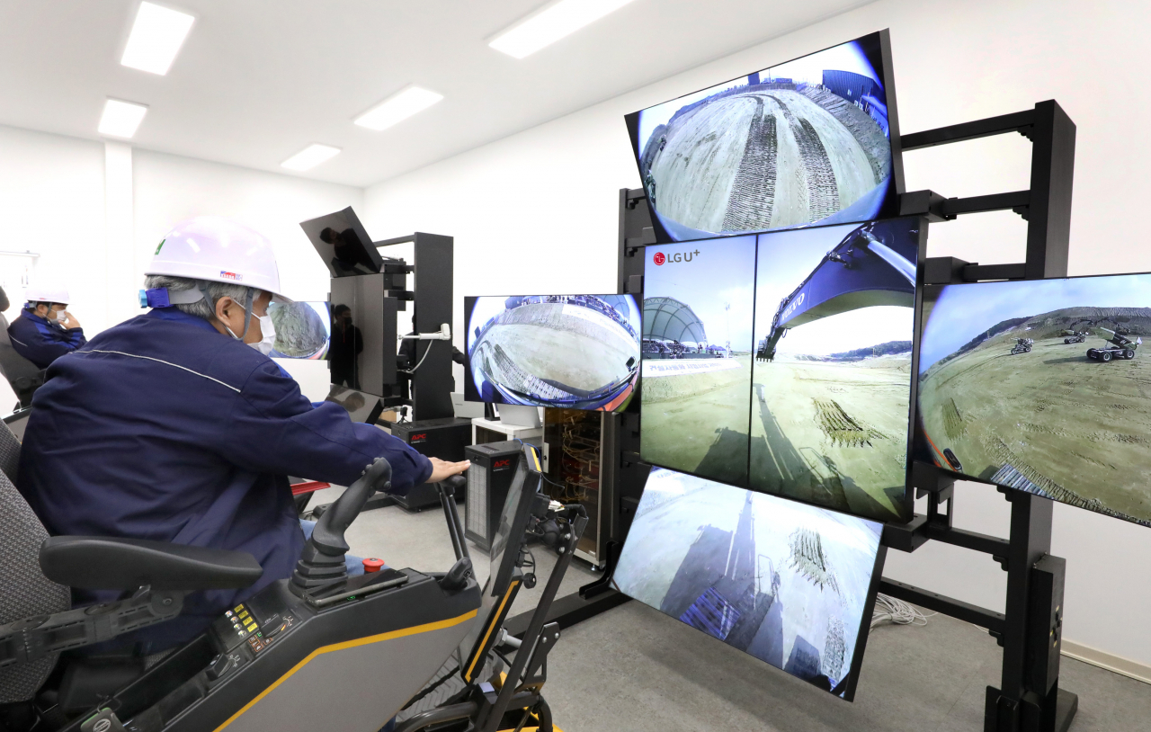 LG유플러스는 세종 스마트시티 국가시범도시 개막식에서 5G 원격제어 건설자동화 장비를 선보였다고 2일 밝혔다. 볼보건설기계 엔지니어들이 원격관제센터에서 5G 원격제어 솔루션의 실시간 영상을 보며 흙을 쌓고 땅을 파는 트렌치 작업을 하고 있다 [LG유플러스 제공]