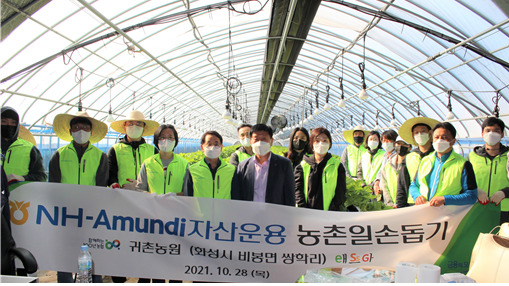 NH-Amundi자산운용 임직원들이 지난달 28일 화성시 딸기 농가 일손돕기에 참여하고 기념촬영을 하고 있다.[NH-Amundi자산운용 제공]