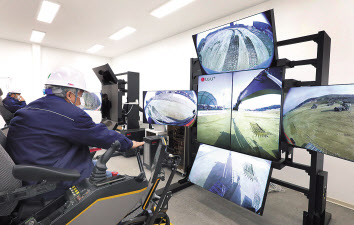 볼보건설기계 엔지니어들이 원격관제센터에서 5G 원격제어 솔루션의 실시간 영상을 보며 흙을 쌓고 땅을 파는 트렌치 작업을 하고 있다. [LG유플러스 제공]