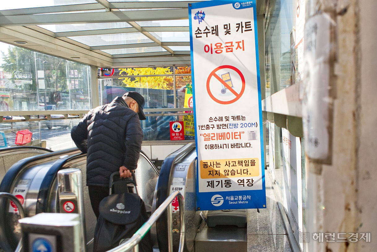 제기동 역에서 한 시민이 손수레를 끌어 에스컬레이터를 타고 있다. 옆에 세워진 손수레와 카트 탑승 금지 안내판이 무색하다. [서울교통공사 제공]