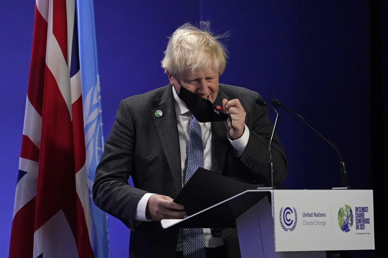 보리스 존슨 영국 총리가 2일(현지시간) 영국 글래스고에서 열린 COP26 총회에서 발언을 위해 마스크를 벗고 있다. [AP]