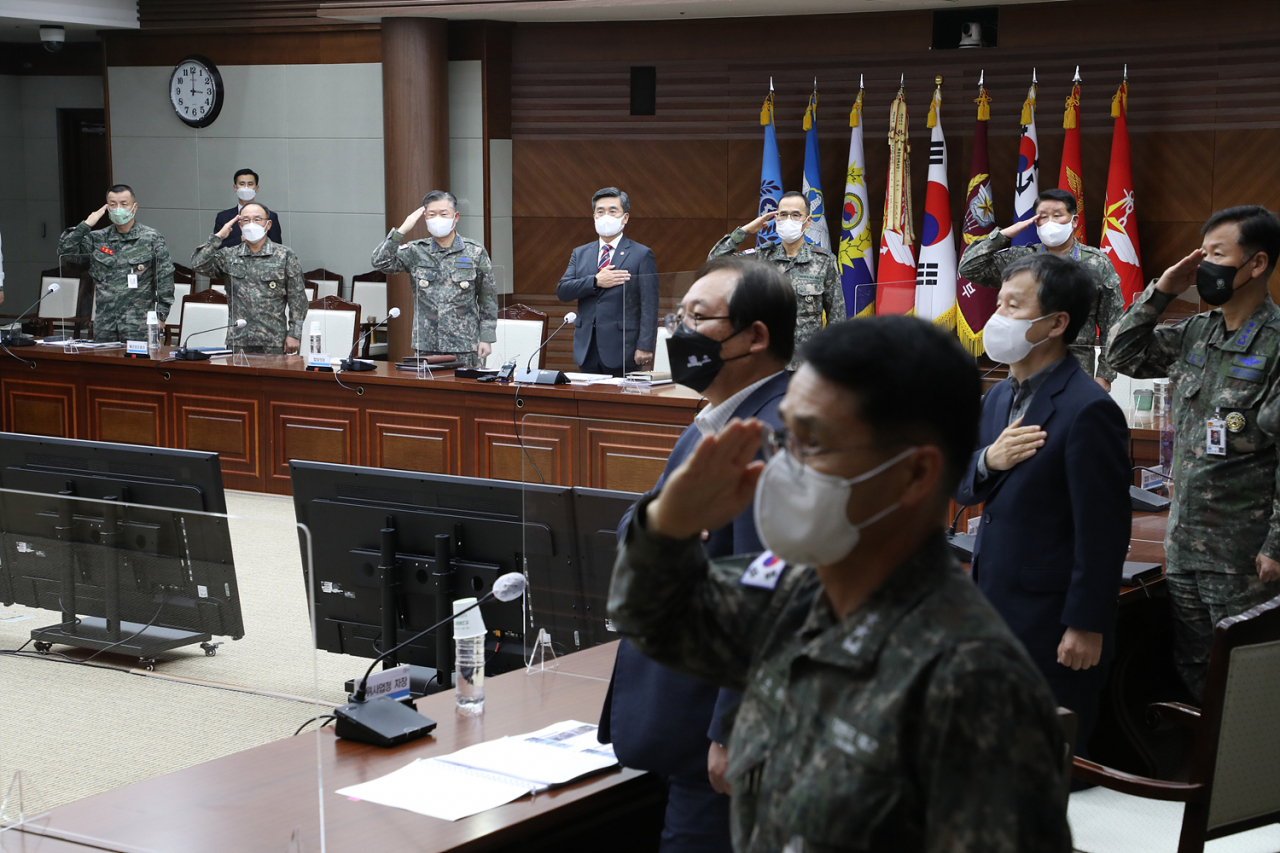 군은 3일 서욱 국방부 장관 주재로 ‘국방우주력발전 추진 평가회의’를 열고 육·해·공군·해병대 등 각군 합동성에 기반한 합동우주작전 수행개념과 수행체계 구축을 추진하기로 했다. 서 장관과 회의 참석자들이 국기에 경례하고 있다. [연합]