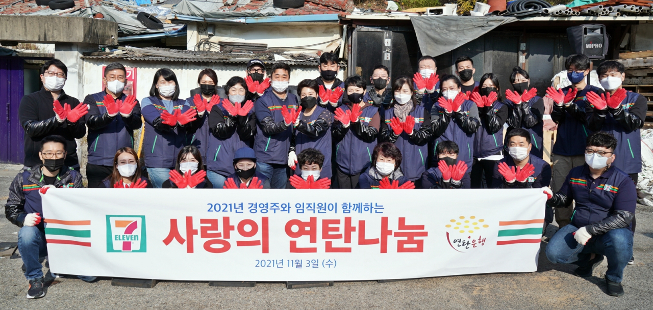 편의점 세븐일레븐의 경영주 및 임직원들이 지난 3일 서울 노원구 백사마을에서 사랑의 연탄나눔 활동을 한 후 기념촬영을 하고 있다. [세븐일레븐 제공]