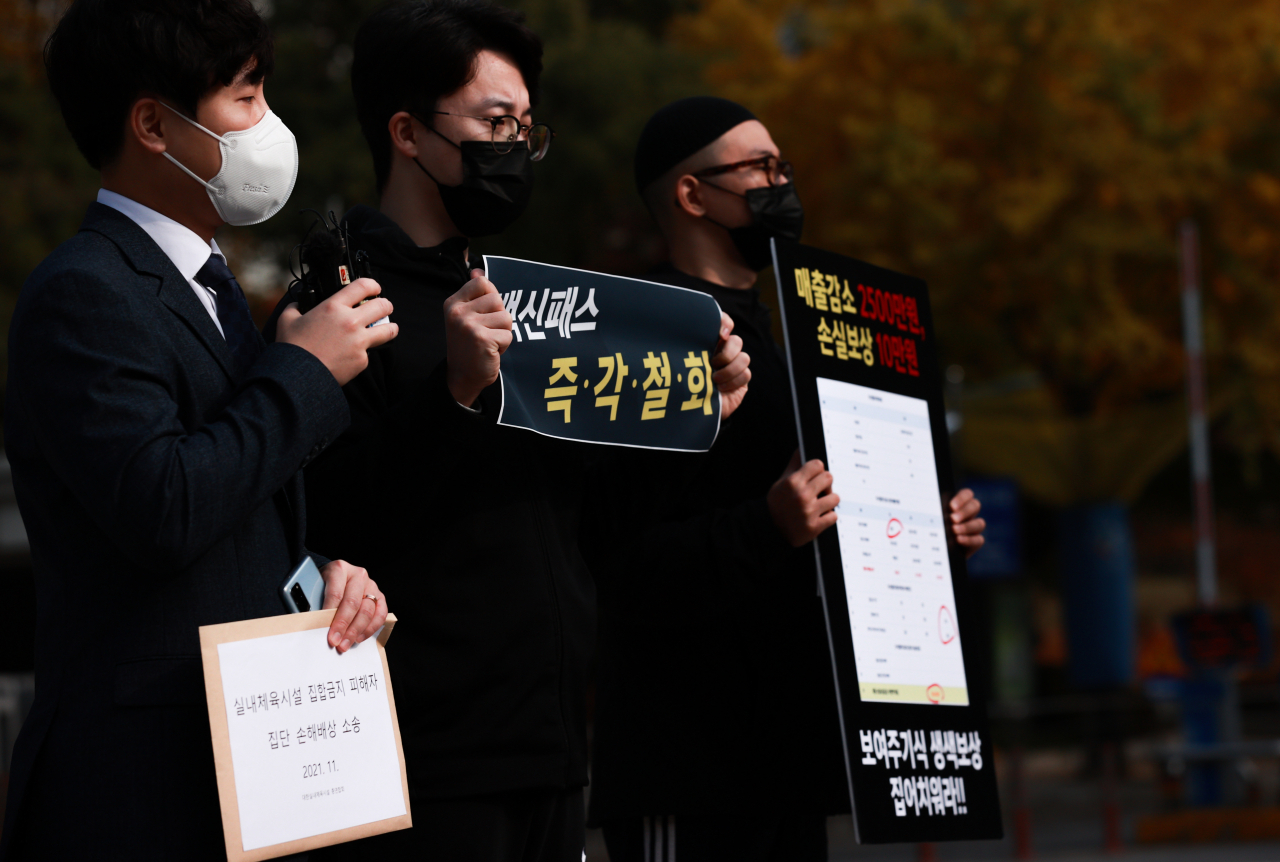 정부는 ‘위드 코로나’(단계적 일상회복) 이행계획 1단계를 이달부터 시행하면서 집단감염 우려가 높다고 판단되는 ▷실내체육시설 ▷목욕장업 ▷노래연습장 ▷경마·경륜·경정·카지노업 등 다중이용시설에 출입할 때 백신 접종 완료 또는 신종 코로나바이러스 감염증(코로나19) 음성을 증명하도록 하고 있다.그런데 아파트 단지 내 실내체육시설 역시 이 지침에 해당한다고 최근 지방자치단체에서 각 단지에 통보하면서 논란을 촉발시키고 있다. 사진은 대한실내체육시설총연합회 박주형 대변인(가운데)과 법무법인 린 배태현 변호사(왼쪽) 등이 4일 오전 서초구 서울중앙지방법원 앞에서 실내체육시설 집합금지 피해자 집단 손해배상 소송과 관련해 소장을 법원에 접수하기 앞서 기자회견을 하는 모습. [연합]