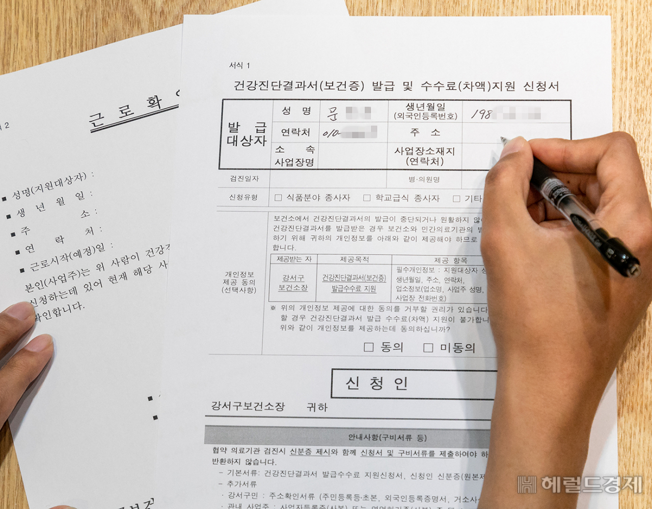 한 민원인이 건강진단서 발급수수료 차액 지원 신청서를 쓰고 있다. [강서구 제공]