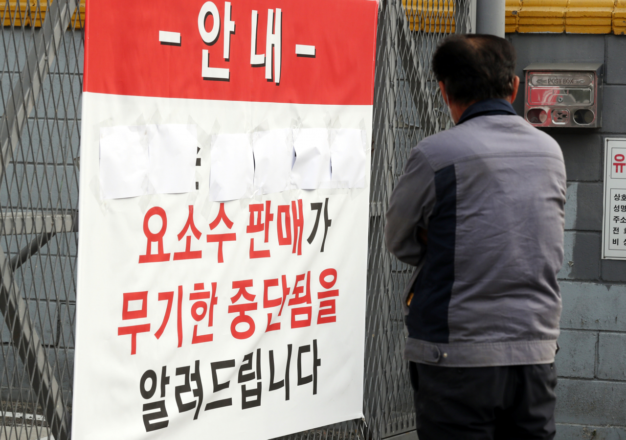 중국발 요소수 품귀 현상이 빚어진 4일 오전 경기도 부천시 한 요소수 제조업체 앞에서 한 트럭 운전사가 '요소수 판매가 무기한 중단됨을 알려드립니다'라고 적힌 안내문을 본 뒤 발걸음을 떼지 못하고 있다. 이 업체는 요소수 제조 원료가 바닥나 요소수를 더는 판매할 수 없다고 설명했다. 연합뉴스