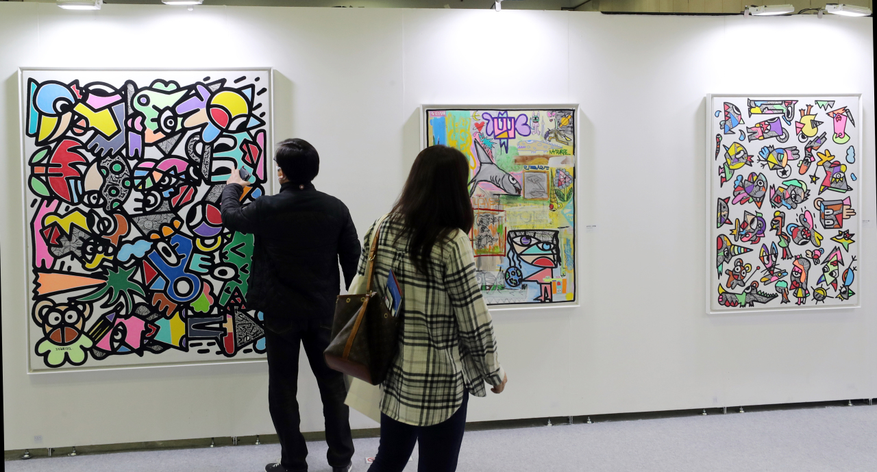Visitors check art pieces displayed at NFT Busan on Thursday. (Yonhap)