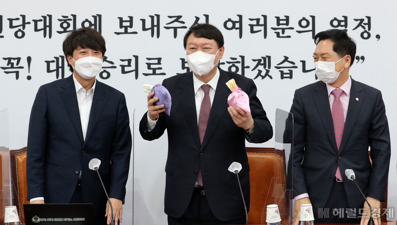 8일 서울 여의도 국회에서 열린 국민의힘 최고위원회의에 참석한 이준석 대표가 당 대선후보인 윤석열 후보에게 ‘선거에 도움이 된다’는 복주머니를 전달하고 있다. [이상섭 기자/babtong@heraldcorp.com]