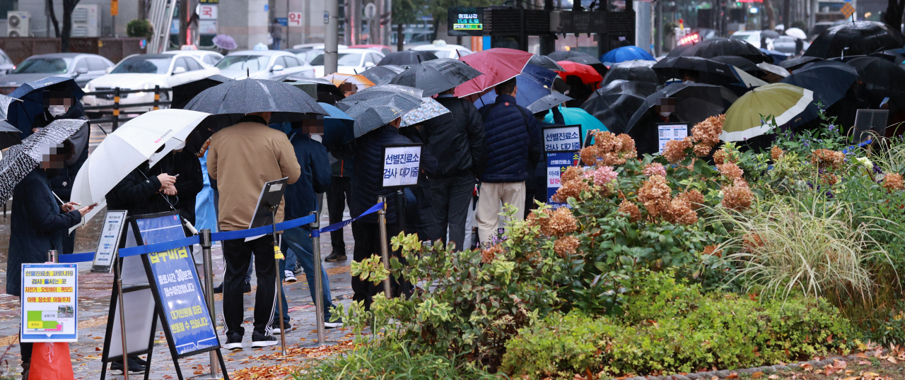8일 오전 서울 송파구 보건소 코로나19 선별검사소에서 시민들이 검사를 받기 위해 우산을 쓴 채 차례를 기다리고 있다. [연합]