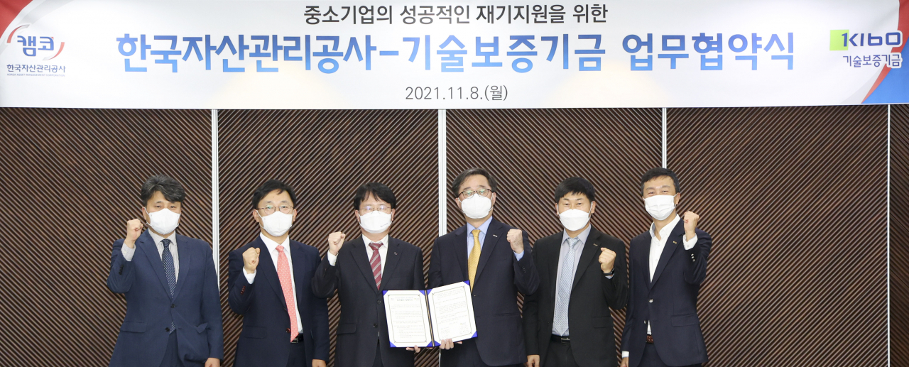 8일 ‘중소기업의 성공적인 재기지원을 위한 업무협약’에서 김귀수 캠코 기업지원본부장(사진 왼쪽 세번째)과 김영갑 기술보증기금 이사(사진 오른쪽 세번째) 및 관계자들이 기념촬영을 하고 있다. [캠코]