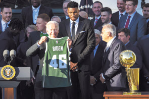 미국의 조 바이든 대통령이 NBA 우승팀 밀워키 벅스 선수들로부터 자신의 이름이 쓰여진 저지를 들어보이고 있다. [USA투데이]
