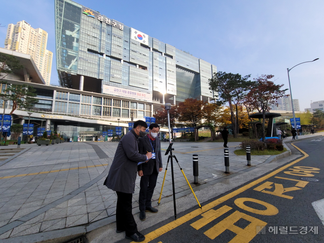 금천구종합청사 앞에서 구청 직원들이 위성측량을 하고 있는 모습. [금천구 제공]