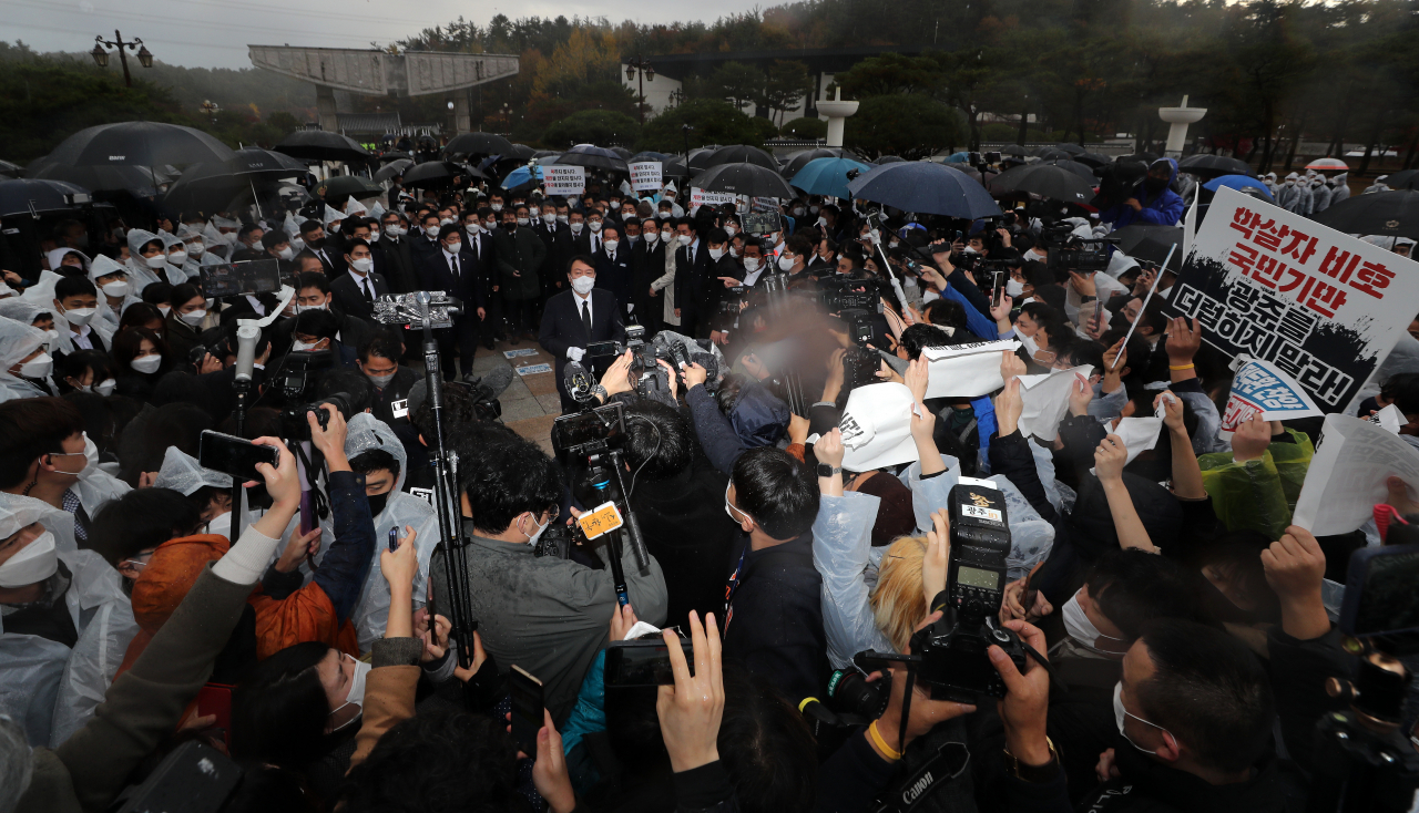 국민의힘 윤석열 대선후보가 10일 광주 북구 국립 5·18 민주묘지를 참배한 뒤 취재진의 질문에 답변하고 있다. 이날 윤 후보는 5·18 민주묘지 추모탑에 헌화·분향하려 했으나 반대하는 시민들에 가로막혀 추모탑 입구에서 묵념으로 참배를 대신했다. [연합]