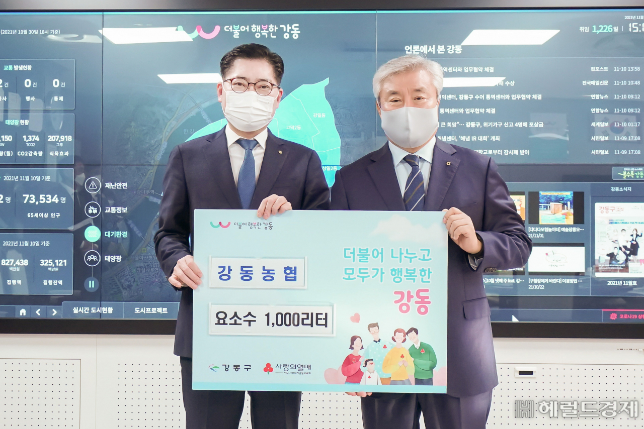 10일 요소수 전달식서 이정훈 구청장과 박성직 강동농협 조합장이 기념촬영을 하고 있다. [강동구 제공]