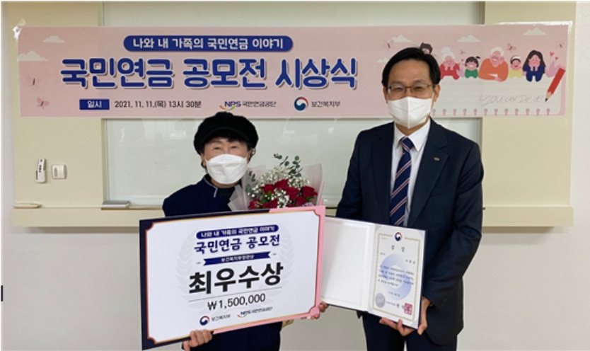 국민연금공단 남울산지사에서 김정학 연금이사(오른쪽)와 최우수상 수상자(왼쪽)가 기념 촬영을 하고 있다. [국민연금 제공]