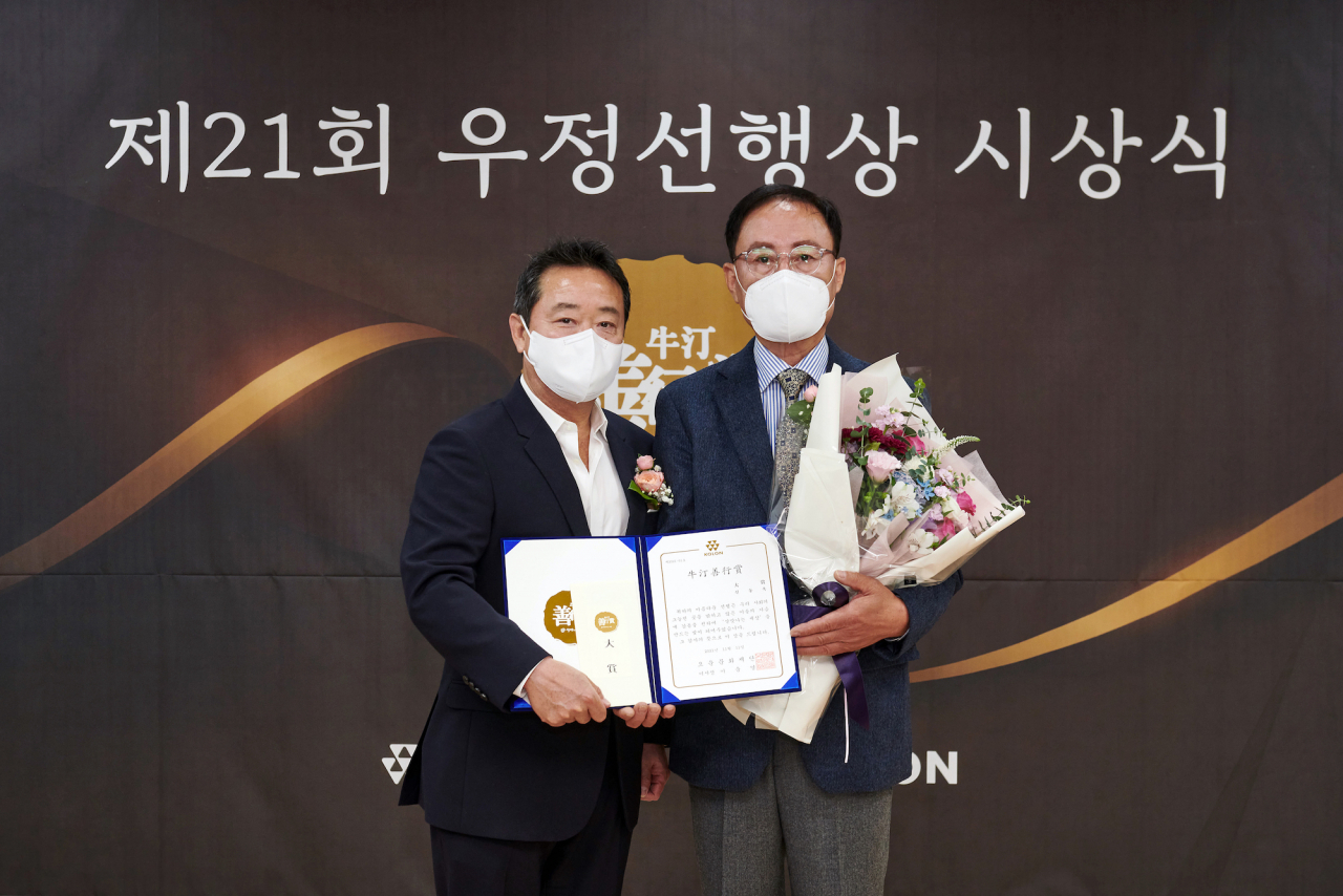 11일 대구 중구 대구남산종합사회복지관에서 열린 제21회 우정선행상 시상식에서 대상을 받은 신동욱 씨(오른쪽)와 이웅열 오운문화재단 이사장이 기념촬영을 하고 있다.[코오롱 제공]
