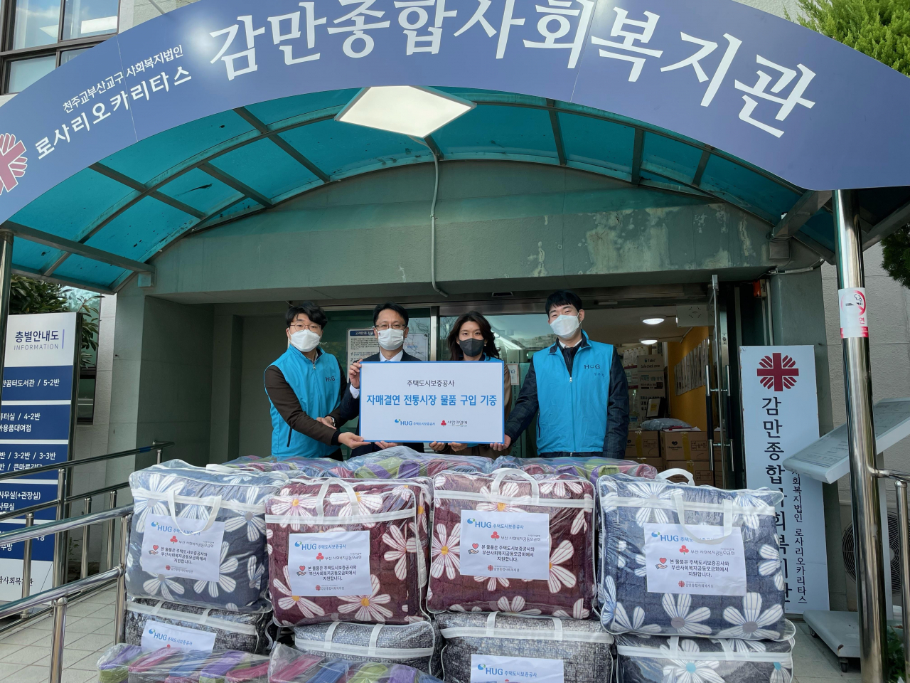 주택도시보증공사(HUG) 직원들이 시장에서 구입한 겨울이불을 사회복지관에 전달하는 모습 [HUG 제공]