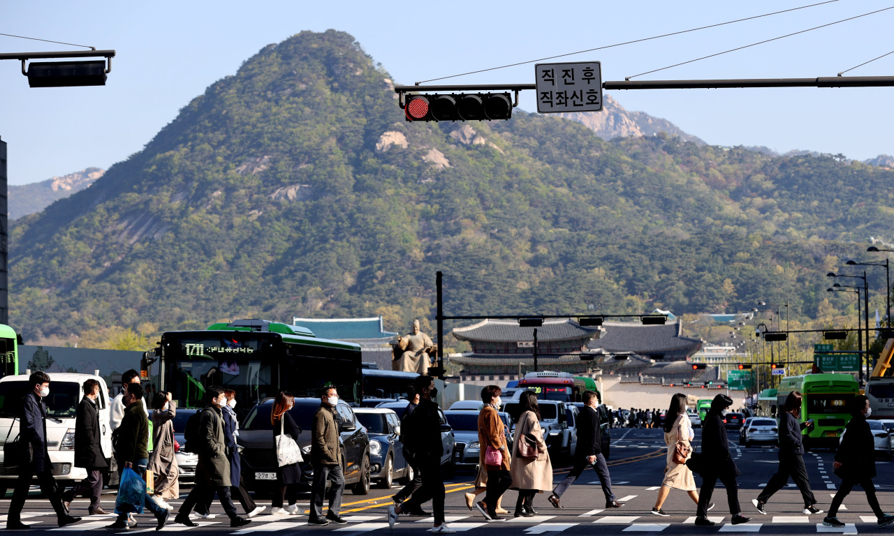 Pedestrians cross a street near Gwanghwamun Square in Seoul (Yonhap)